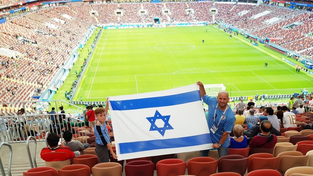 אבי ובנו טום מניפים את דגל ישראל באיצטדיון