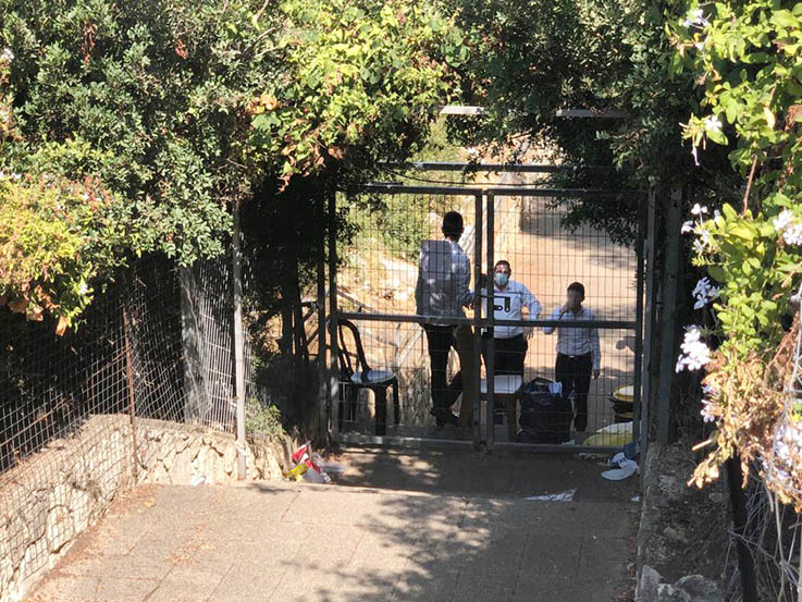 בחורי ישיבה במתחם רינה של תורה. השערים נעולים. צילום: גיל דובריש
